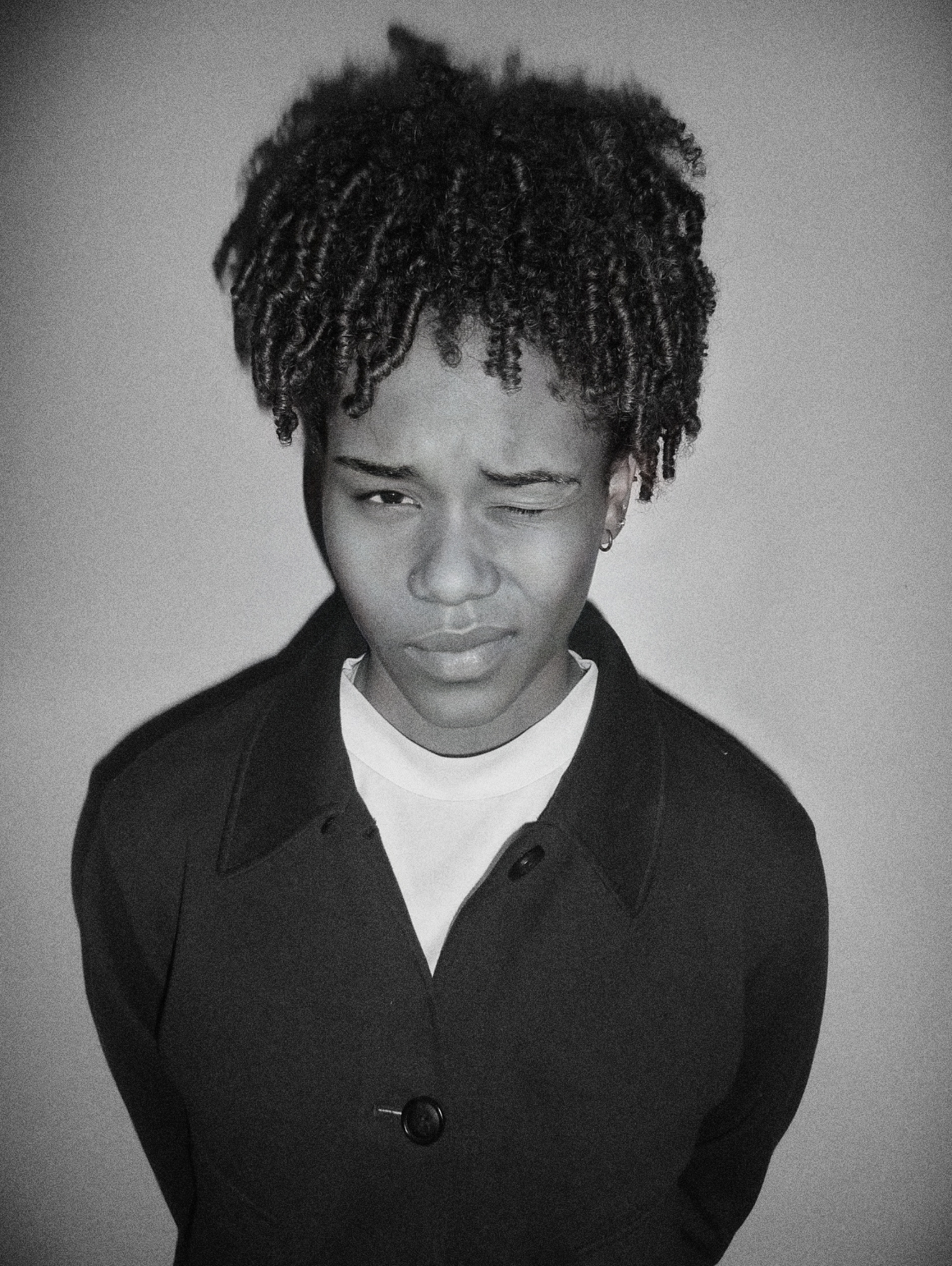 Aliana White winking in a black-and-white studio portrait